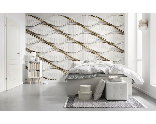 Schlafzimmer mit Bett und Wandtapete mit Holzstäbchen und goldenen Kugeln