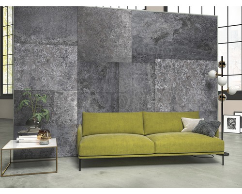 Wohnzimmer mit grauen Wandfliesen in Steinoptik und gelbem Sofa