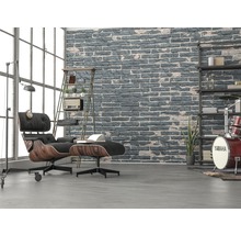 Wohnzimmer mit Sessel, Hocker, Regal und Ziegelwand