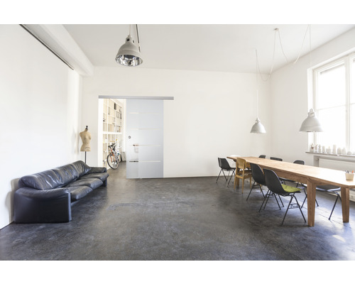 Heller Raum mit Sofa, Schiebetür, Tisch und Stühlen