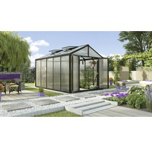 Gewächshaus mit geöffneter Tür in einem Garten mit Terrasse und Blumenbeeten