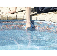 Person reinigt einen Pool mit einem Reinigungsschwamm.
