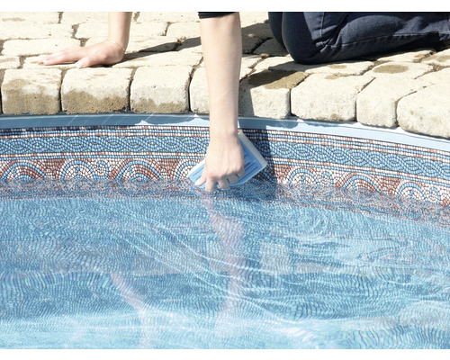 Person reinigt einen Pool mit einem Reinigungsschwamm.