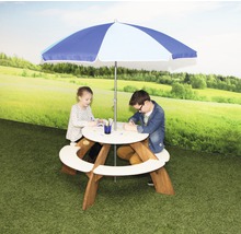 Kinder sitzen an einem runden Picknicktisch mit Sonnenschirm im Garten.