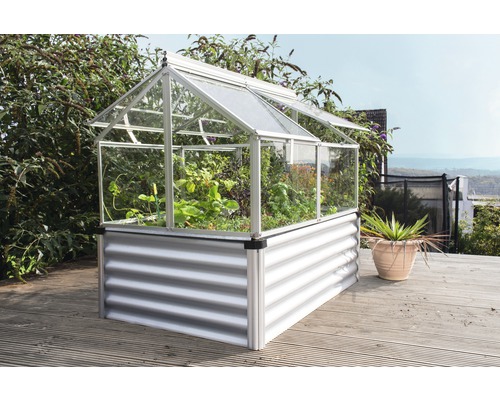 Gewächshaus mit Hochbeet aus Metall und Pflanzen auf einer Holzterrasse