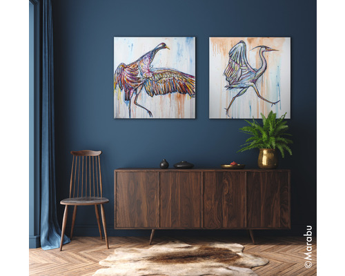 Wohnzimmer mit zwei Vogelbildern, Holzkommode, Stuhl und Teppich