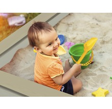 Kind spielt mit Sandkastenspielzeug im Sandkasten