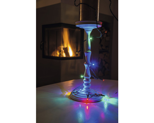 Kerzenständer mit Lichterkette und Kamin im Hintergrund