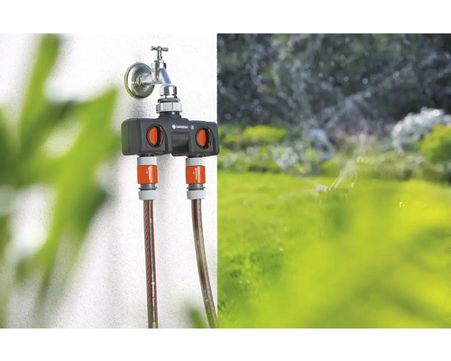 Gardena Wasserverteiler an einem Wasserhahn mit zwei angeschlossenen Gartenschläuchen.