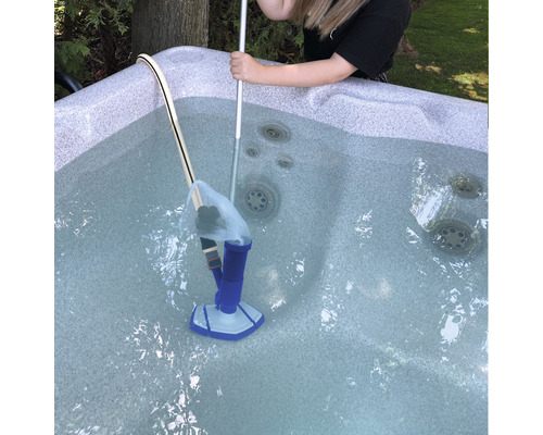 Person reinigt einen Whirlpool mit einem Staubsauger