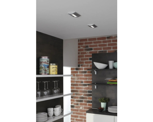 Küchenszene mit Deckenspots, Backsteinmauer und offenen Regalen mit Geschirr