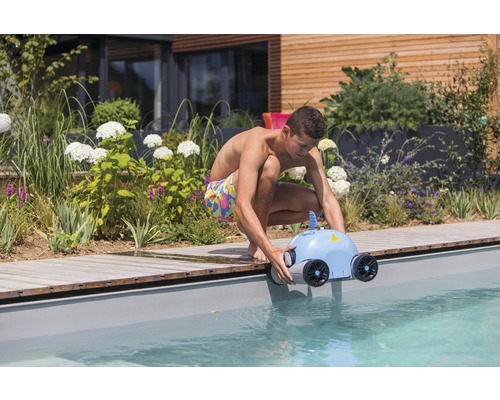 Mann setzt einen Schwimmbadreinigungsroboter ins Becken.