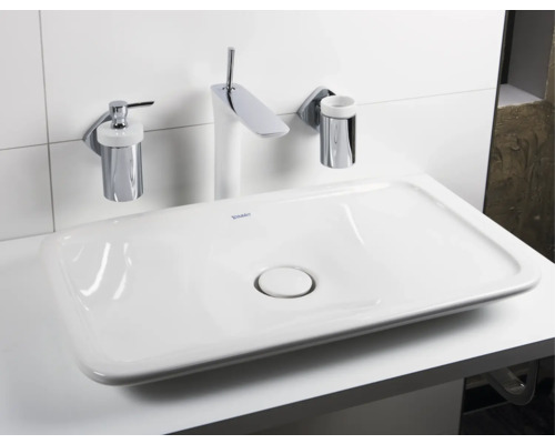 Waschbecken mit Armatur, Seifenspender und Becherhalter im Badezimmer
