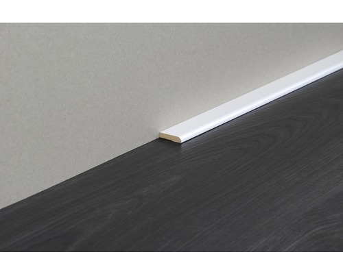 Weiß lackierte Sockelleiste an dunklem Holzboden