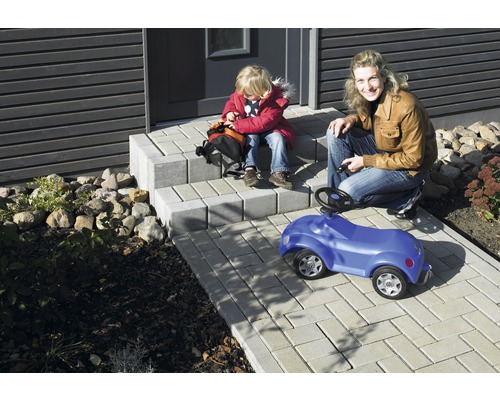 Außenaufnahme mit Pflastersteinen auf Terrasse mit Mutter und Kind