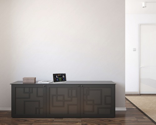 Wetterstation auf einer Kommode in einem hellen Raum.