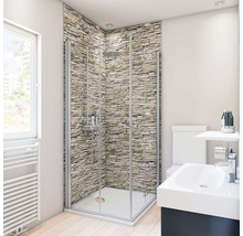 Badezimmer mit Duschkabine, Waschtisch und Toilette vor einer Steinwand