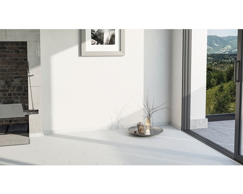 Heller Raum mit Fliesenboden, gemauertem Kamin und Ausblick ins Grüne