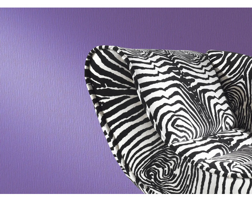 Sessel mit Zebra Muster vor lila Wand