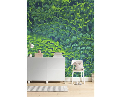 Wohnraum mit einer grünen Tapete mit Federdesign, Kommode und Stuhl