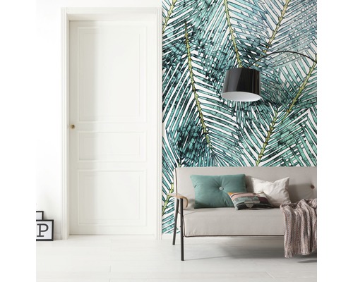 Wohnraum mit Tür, Sofa und Wandtapete mit Palmenblattmuster