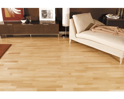 Wohnraum mit hellem Holzboden, Sofa und Kommode