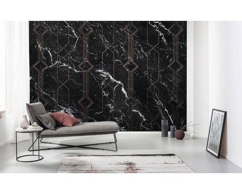 Wohnraum mit einer schwarzen Marmortapete mit geometrischen Mustern, einem grauen Liegestuhl und dekorativen Elementen.