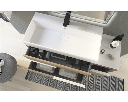 Badezimmer mit Waschbecken, Unterschrank mit Auszügen, Handtüchern und Badartikeln