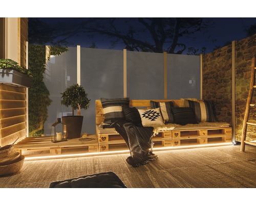 Gemütliche Outdoor-Lounge mit Palettenmöbeln, Kissen und Beleuchtung für Garten oder Terrasse.