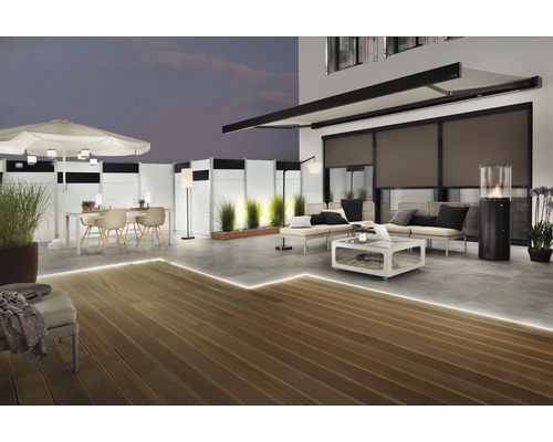 Terrasse mit Holzdeck, Terrassenmöbeln, Markise und Beleuchtung für den Außenbereich.