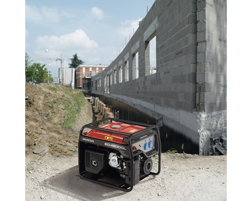 Honda Stromerzeuger auf einer Baustelle vor einem Gebäude im Bau.