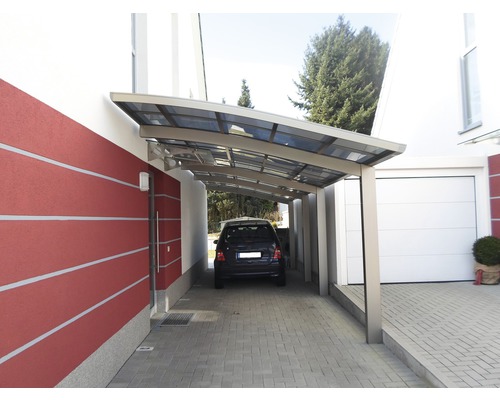 Auto unter einem Carport neben einem Haus mit Garage