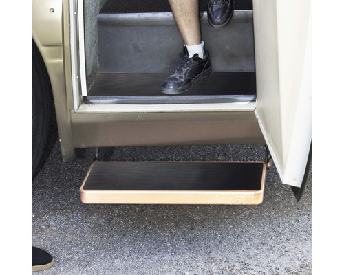 Ausfahrbare Trittstufe an einem Wohnmobil mit Person, die die Stufen benutzt.