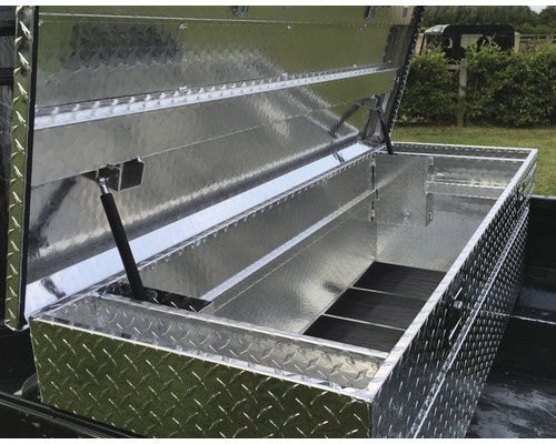 Geöffnete Werkzeugkiste aus Aluminium mit Riffelblechmuster auf einer Ladefläche