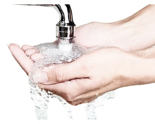 Eine Person hält die Hände unter einen Wasserhahn, aus dem Wasser fließt.