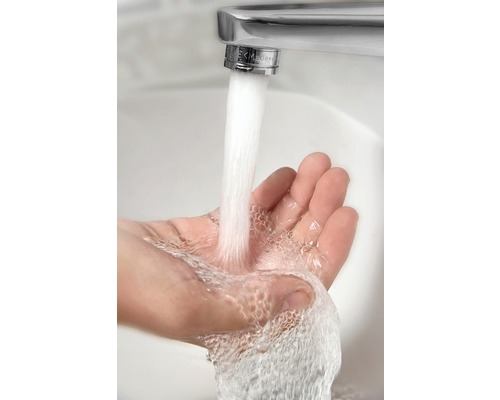 Wasserhahn mit laufendem Wasser über einer Hand