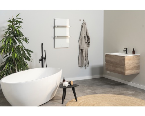 Badezimmer mit freistehender Badewanne, Waschtisch, Handtuchwärmer und Bademantel