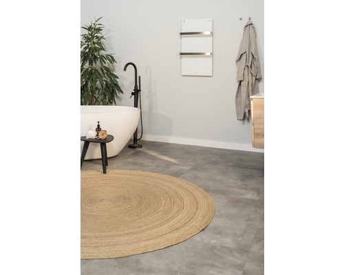 Badezimmer mit freistehender Badewanne, rundem Teppich und Handtuchwärmer