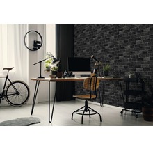 Arbeitszimmer mit Schreibtisch, Stuhl, Fahrrad und Backsteintapete