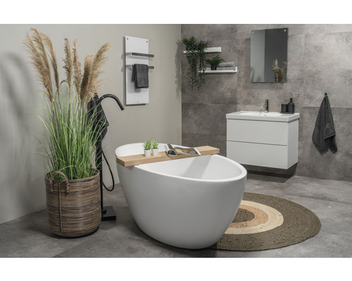 Badezimmer mit freistehender Badewanne, Waschtischunterschrank, Spiegel, Handtuchwärmer und Dekoration