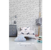 Kinderzimmer mit Bett, Kommode, Leiter und Dekorationsartikeln vor einer Tapete im Backsteindesign