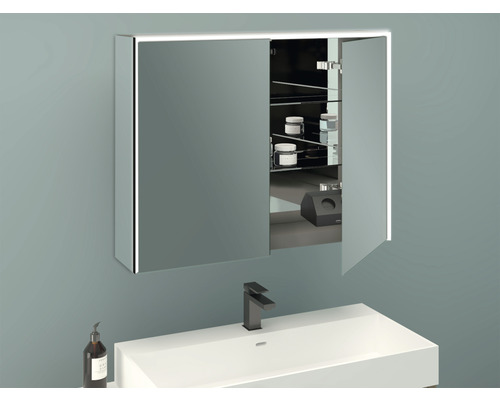 Spiegelschrank mit Beleuchtung über Waschbecken mit Armatur und Seifenspender