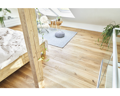 Heller Dachboden mit Holzboden, Bett, Teppich und Sitzgelegenheit