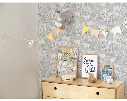 Kinderzimmer mit Tiermotiven Tapete, Girlande, Bildern und Spielzeugkommode.