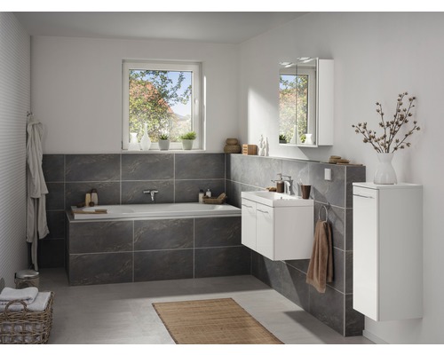 Badezimmer mit Badewanne, Waschbeckenunterschrank, Spiegelschrank und Hochschrank in hellem Design