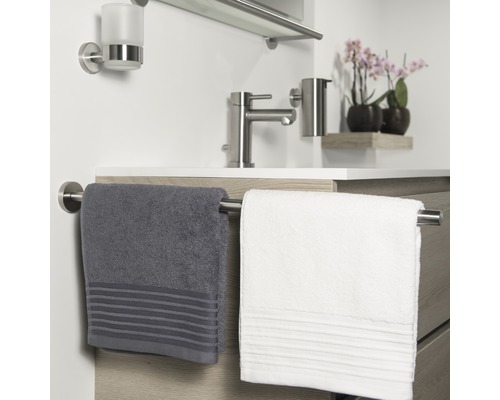 Modernes Badezimmer mit Waschtisch, Armatur, Handtuchhaltern und Handtüchern