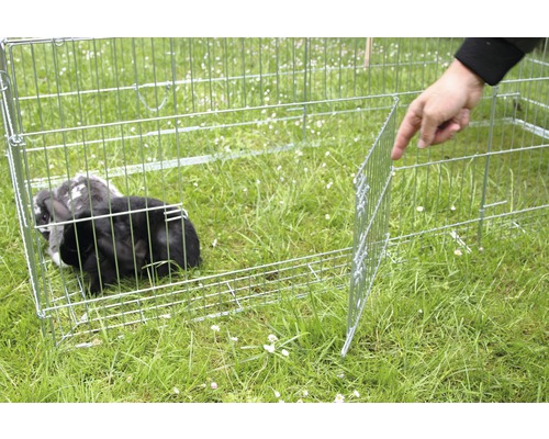 Freilaufgehege aus Metall mit Kaninchen auf einer Wiese