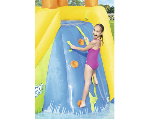 Mädchen klettert auf einer aufblasbaren Wasserrutsche mit Kletterwand