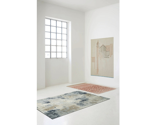 Helle Räumlichkeit mit zwei Teppichen und einem Bild an der Wand.