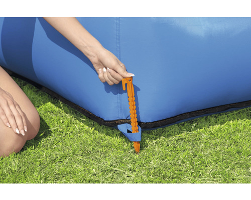 Detailansicht eines Erdnagel zur Befestigung eines blauen aufblasbaren Sofas im Garten.